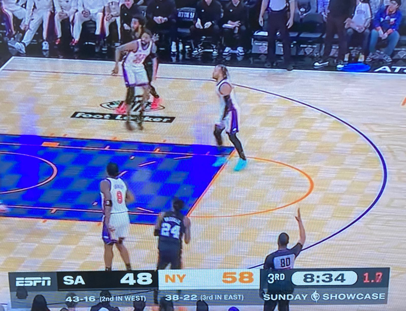 photo of a tv set showing a baseketball game between the nicks and the spurs cropped to make the score bug prominent